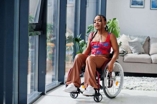 Young disabled African American woman in wheelchair at home.
